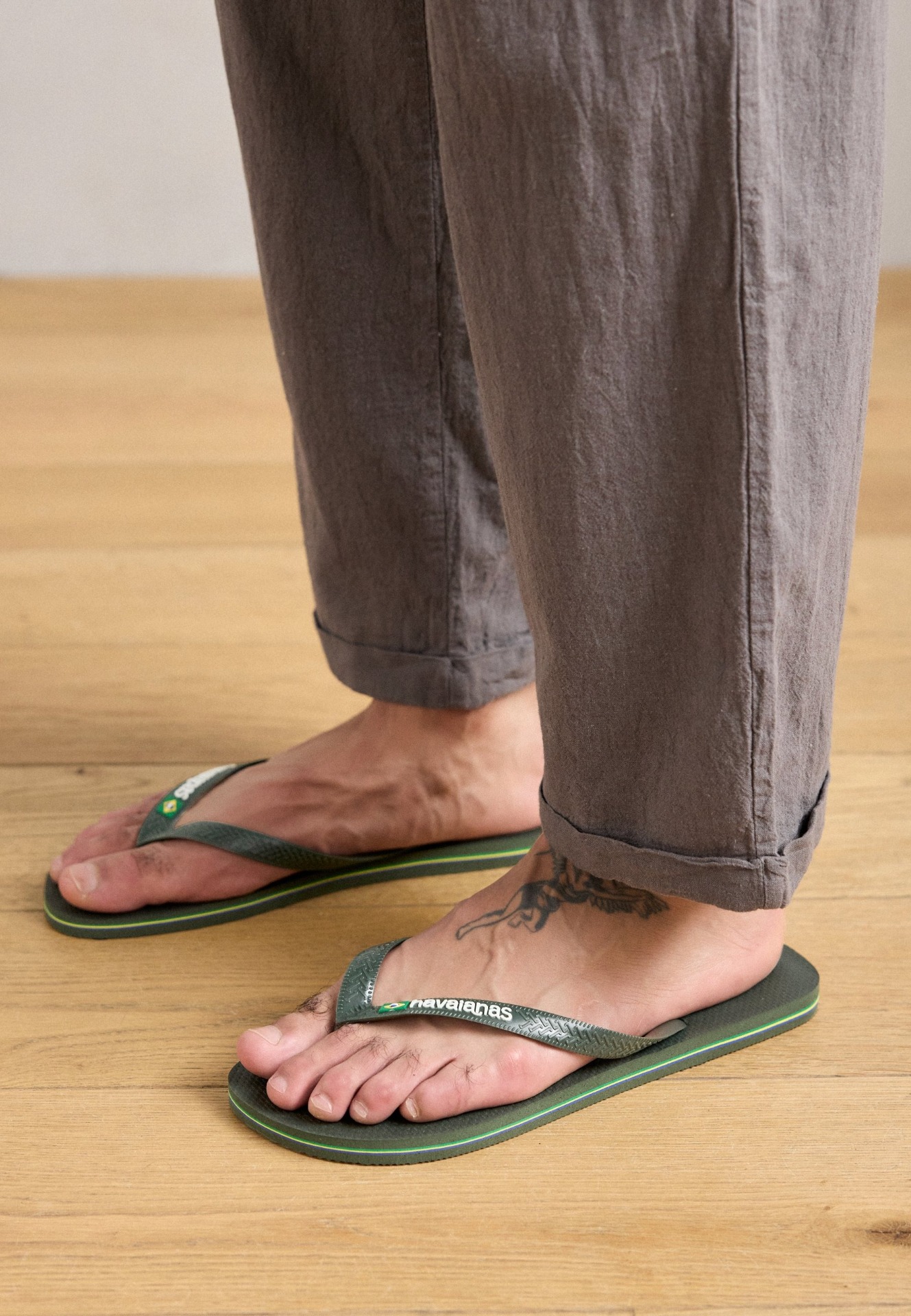 personne portant un pantalon brun  , pieds nus et des tongs vertes 